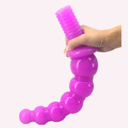 Plug anale viola flessibile tenuto in mano per mostrare curvatura