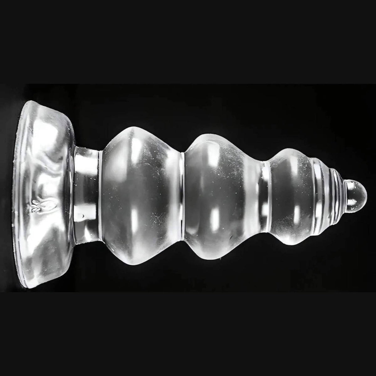 Plug anale trasparente Chikubi a gradini con ventosa base su sfondo nero