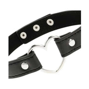 Dettaglio cuore metallico lucido e fibbie argentate su choker pelle vegana nero
