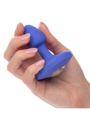 Mano femminile che tiene plug anale vibrante blu con pietra diamantata