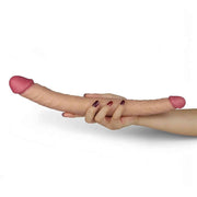 Doppio dildo rosa carne tenuto in mano per mostrare flessibilità
