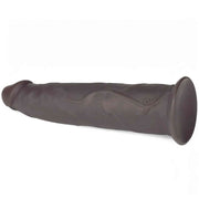 Dildo vibrante nero in silicone posizionato orizzontalmente con logo DC e base piatta stabile