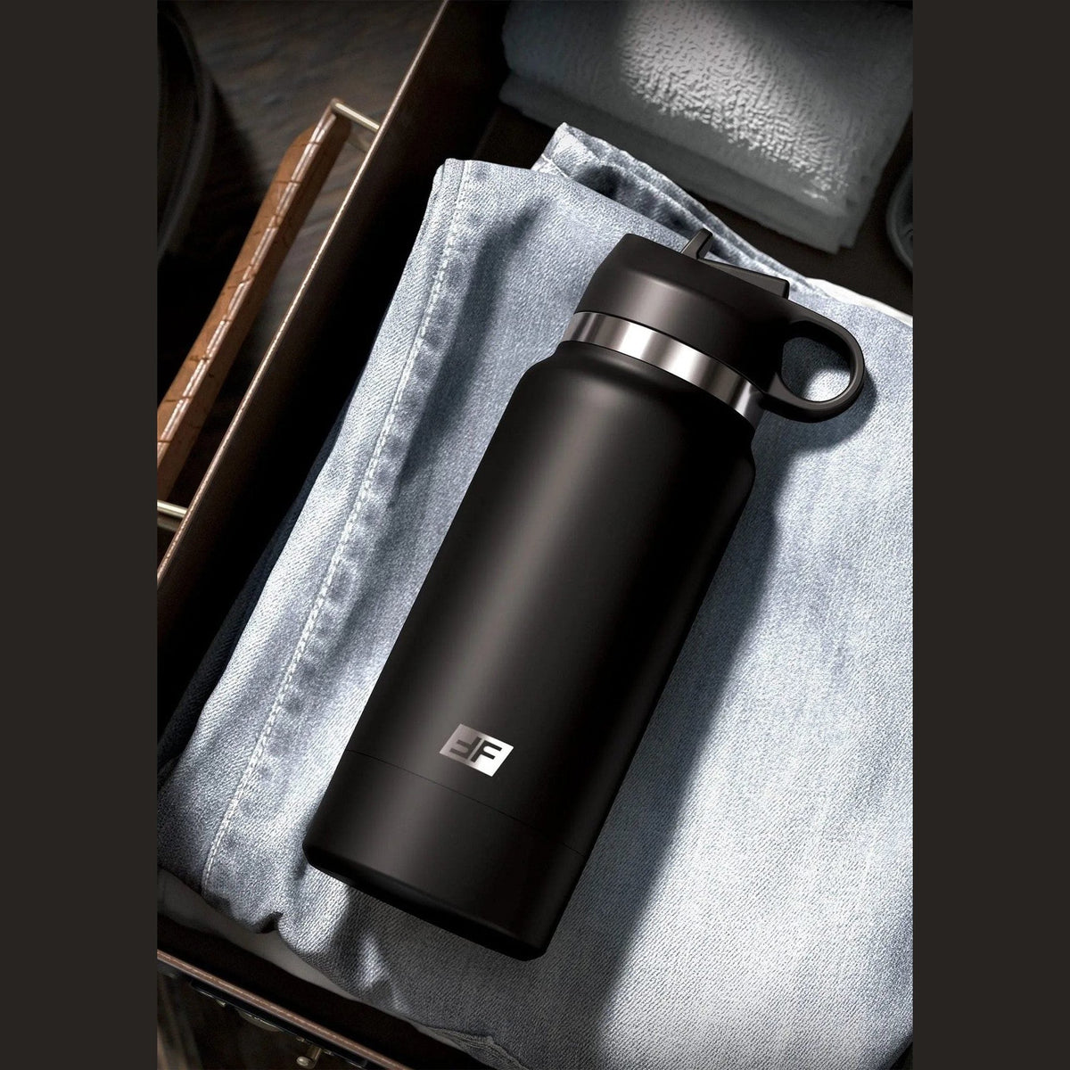 Fap Flask Thrill Seeker nero riposto in valigia su tessuto jeans