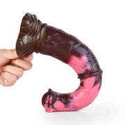 Dildo fantasy Gightning flessibile in silicone rosa e nero tenuto in mano per mostrare curvatura