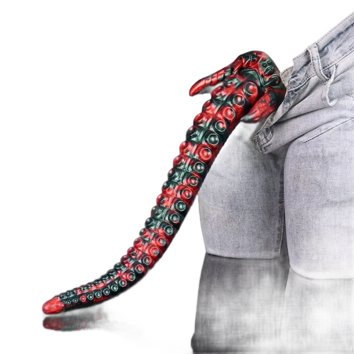 Dildo tentacolo mostro rosso verde in silicone accanto a jeans per scala