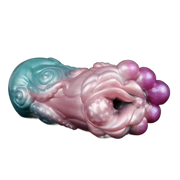 Toy in silicone liquido bicolore turchese e rosa con dettagli tentacoli, texture floreale e sfere viola