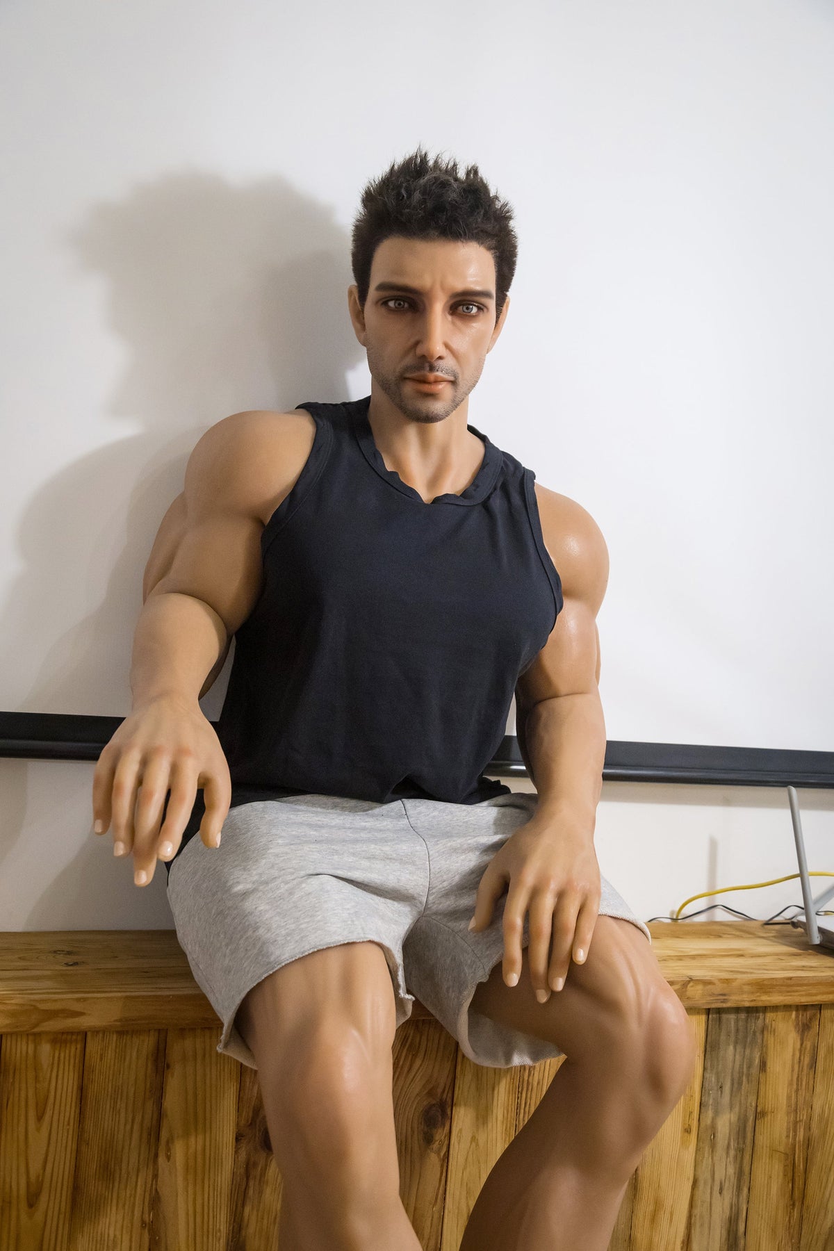 Manichino uomo muscoloso seduto banco legno maglietta senza maniche