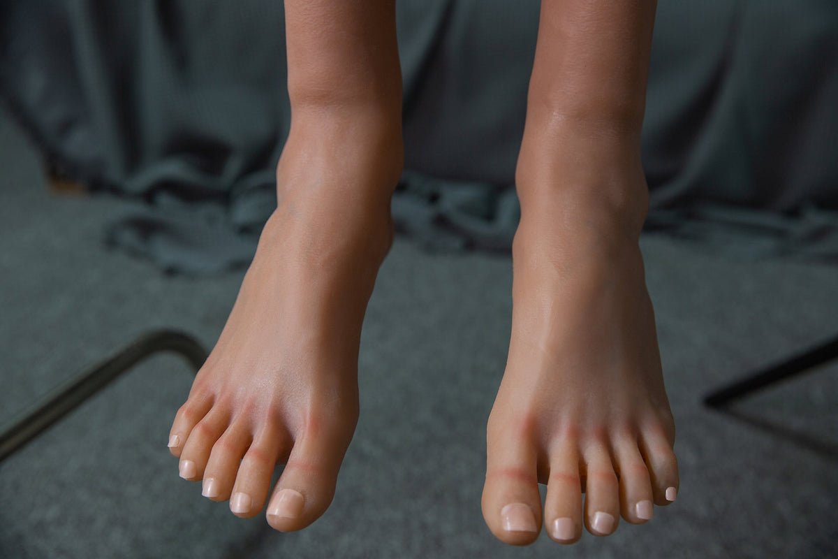 Piedi primo piano manichino uomo realistico unghie curate pavimento grigio