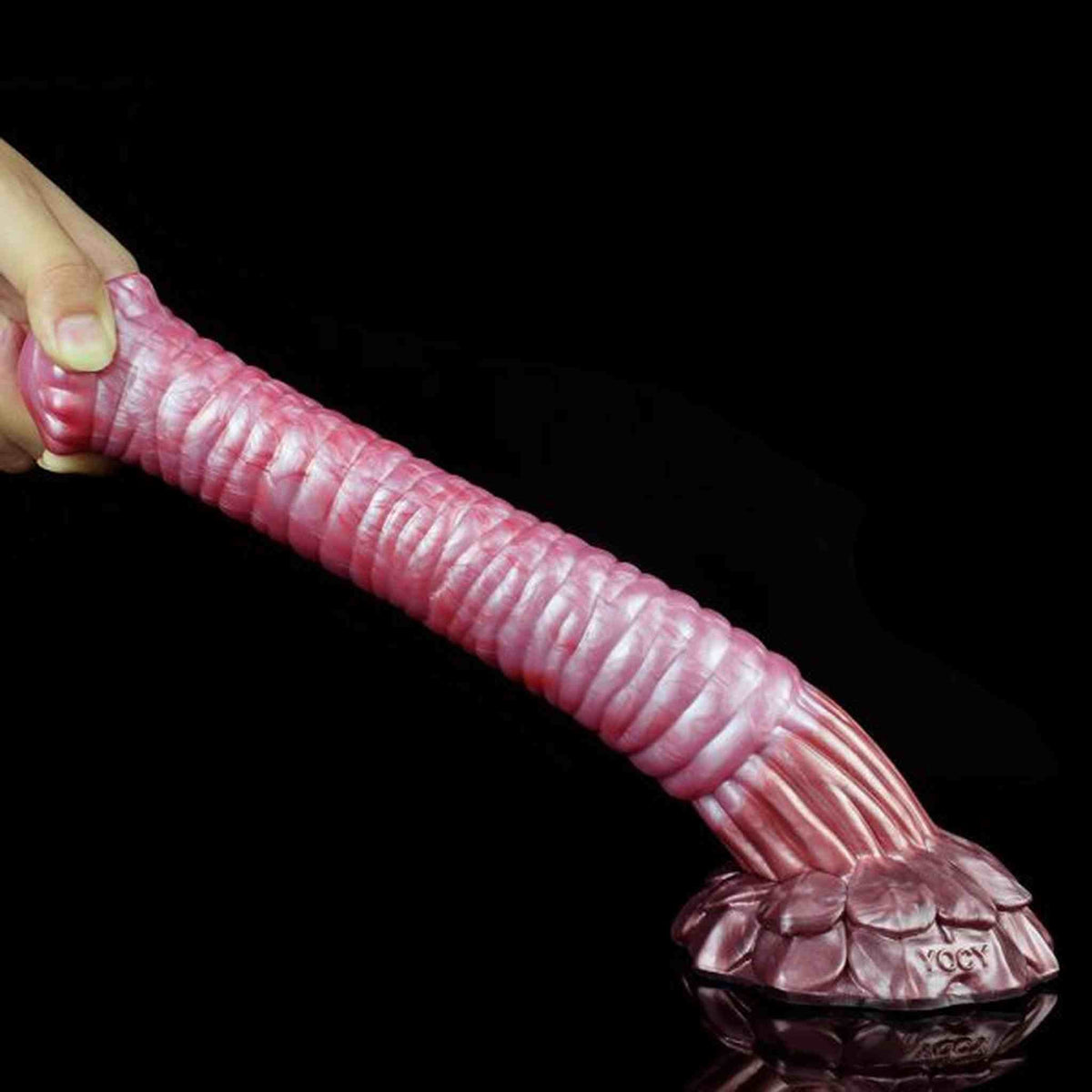 Dildo rosa opaco Srepnia con marchio YOCY inciso, tenuto in diagonale