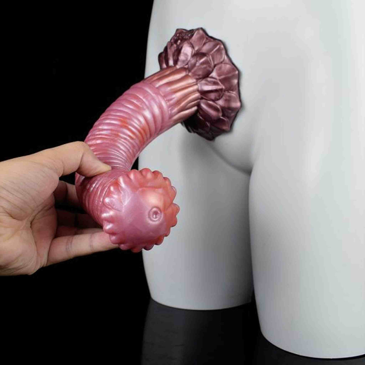 Dildo rosa flessibile Srepnia tenuto in mano, testa a fiore con dettagli