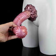 Dildo rosa flessibile Srepnia tenuto in mano, testa a fiore con dettagli