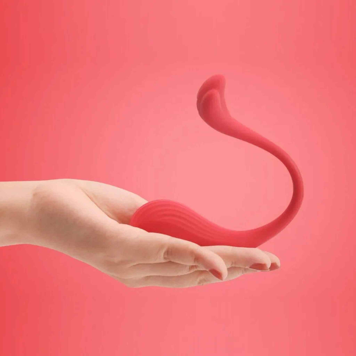 Mano femminile che tiene ovulo rosso ergonomico a forma di C
