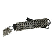 Dettaglio laterale frustino pelle nera con rivestimento catene argento