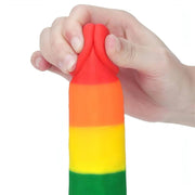 Primo piano testa rossa dildo silicone arcobaleno premuta per dimostrare morbidezza