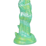 Dildo drago iridescente verde giallo vista laterale scaglie dettagliate riflessi metallici