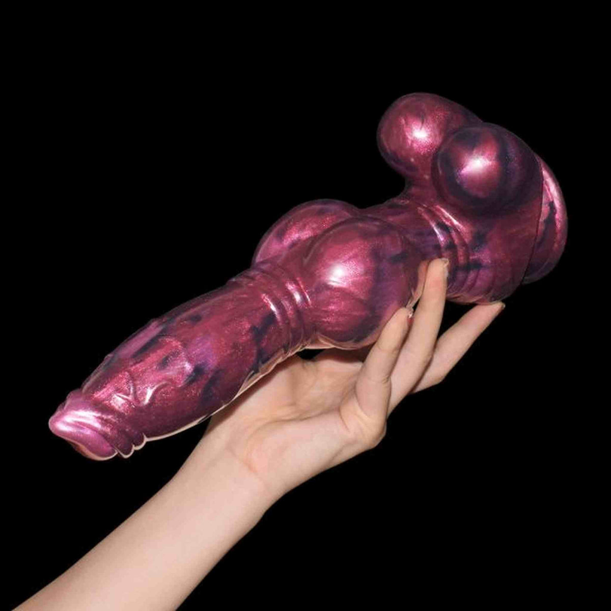 Dildo iridescente viola nero Magmara Ringo con protuberanze laterali tenuto in mano