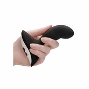 Dettaglio texture morbida stimolatore prostatico nero in silicone tenuto in mano su sfondo bianco