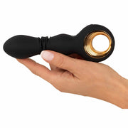 Vibratore nero in silicone con anello dorato tenuto in mano per mostrare ergonomia