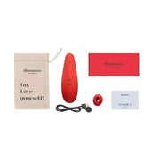 Composizione piatta accessori Womanizer rosso borsa ricarica e manuale