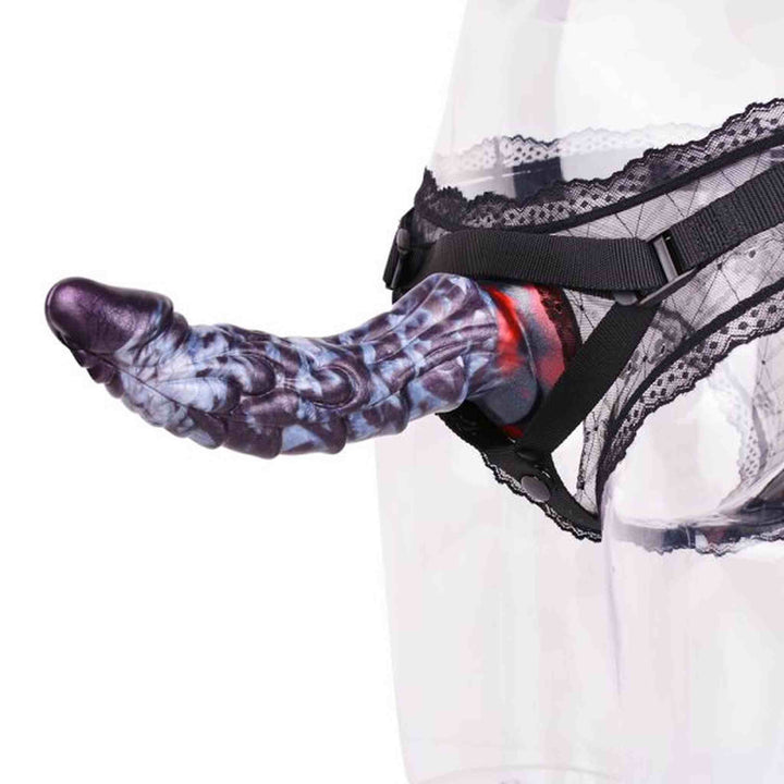 Dildo in silicone viola montato su supporto nero con dettagli texture corpo